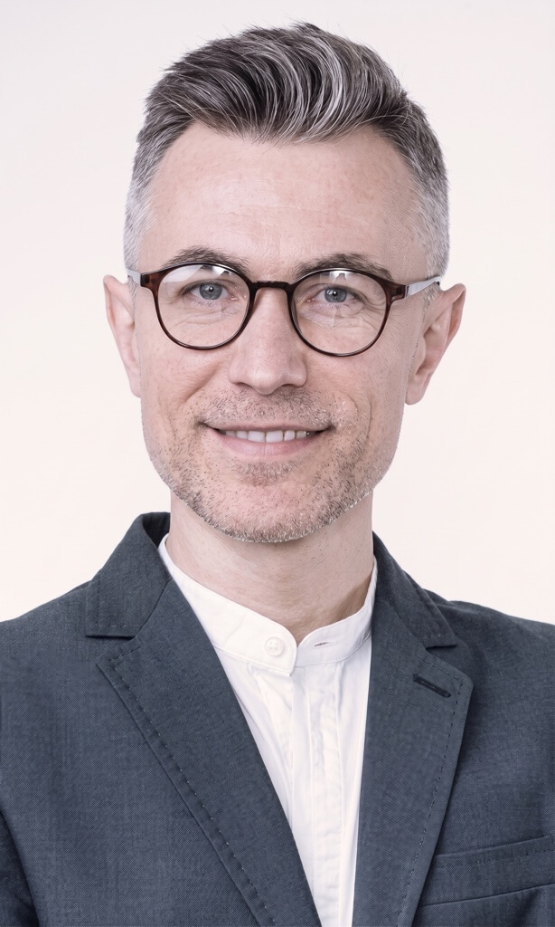 Smiling man with glasses and grey hair