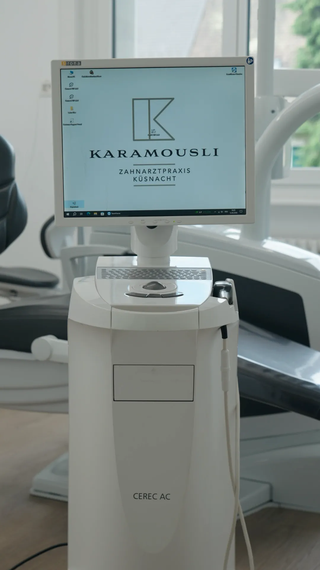 CEREC AC mit dem Logo der Zahnarztpraxis Karamousli auf dem Bildschirm